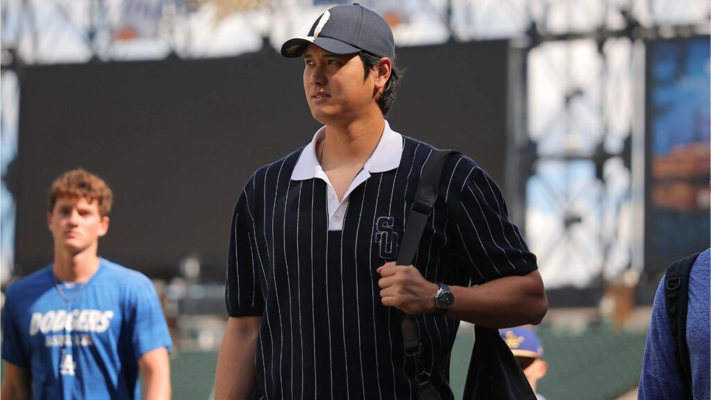 Shohei Ohtani to miss the All-Star Game, raising concerns for the Dodgers Ohtani walks toward the clubhouse wearing a black shirt with white stripes and a black cap
