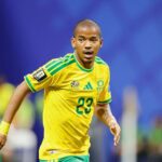 The South African player running across the field in his national team's yellow kit