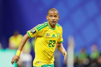The South African player running across the field in his national team's yellow kit