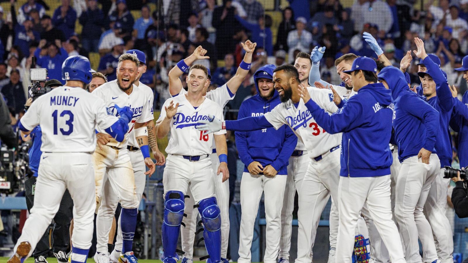The Dodgers players waiting at home plate for one of their teammates after he scored the game-winning run