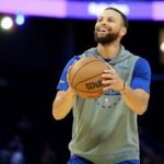 Curry taking a free throw while smiling during a practice session