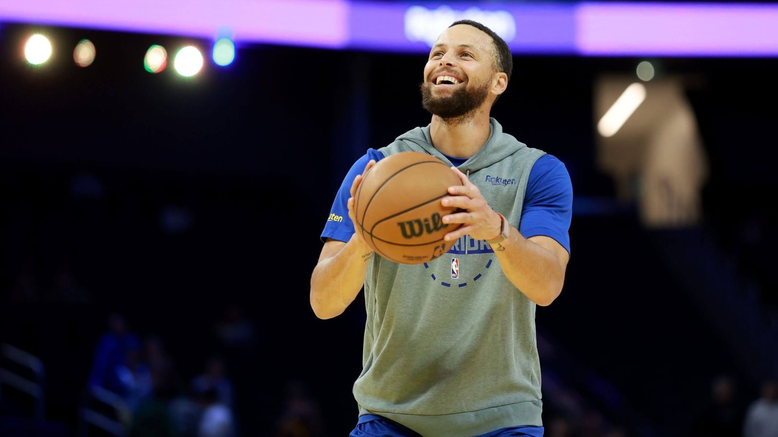 Curry taking a free throw while smiling during a practice session