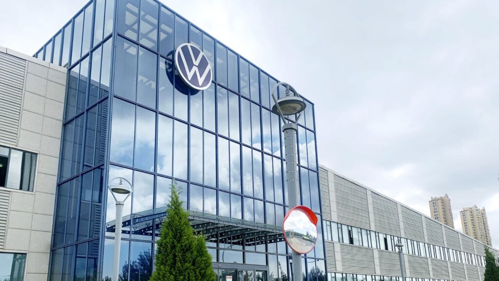 Thousands of Volkswagen workers rise up over fears of mass layoffs One of the automaker's office buildings featuring a large glass entrance and its iconic logo displayed above it
