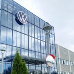 One of the automaker's office buildings featuring a large glass entrance and its iconic logo displayed above it