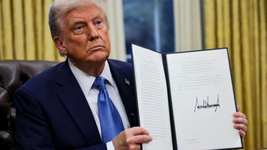 Donald Trump holding the tariff executive order, a large document bearing his signature