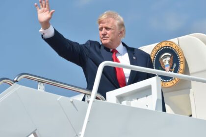 Trump waving to people as he boards his private jet