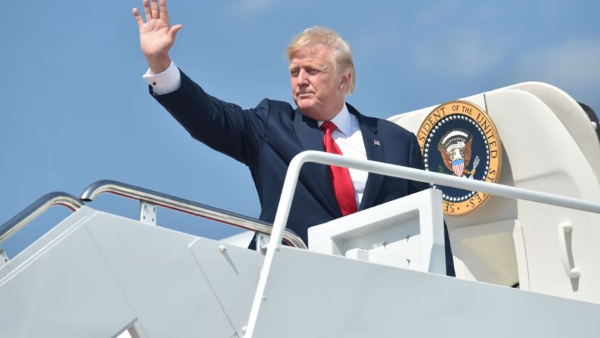 Trump waving to people as he boards his private jet