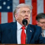 "Trump speaking into a microphone in front of a large crowd