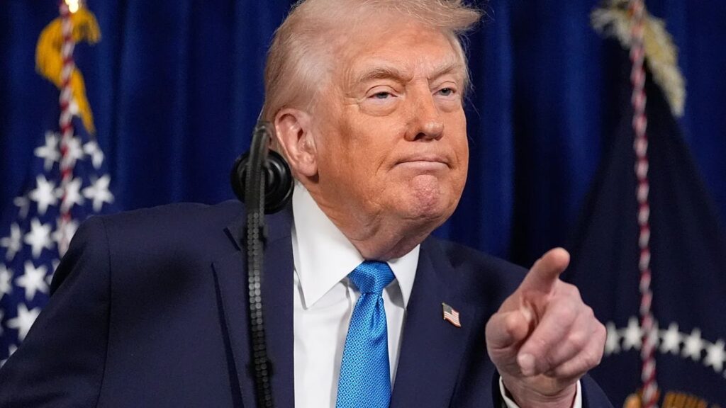 Donald Trump pointing with his finger while delivering a speech behind a podium
