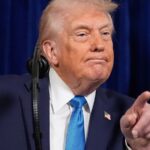 Donald Trump pointing with his finger while delivering a speech behind a podium