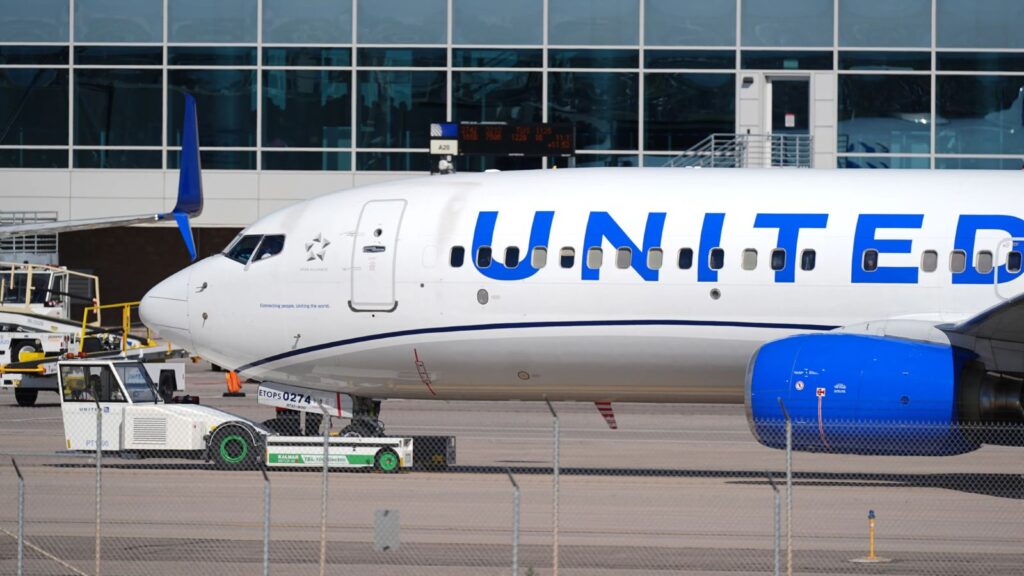 An aircraft from the airline parked at an airport, featuring its iconic white livery and blue lettering