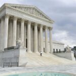 A panoramic view of the United States Supreme Court building, showcasing its massive walls and beautiful fountain