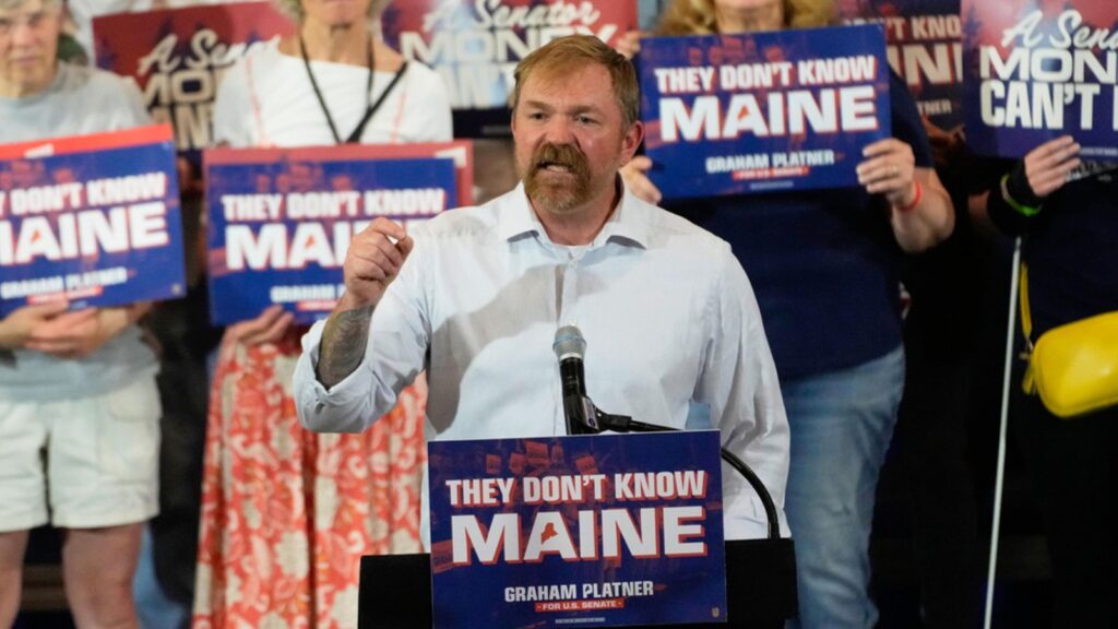 The Senate candidate standing at a podium, addressing a crowd of supporters during his campaign rally