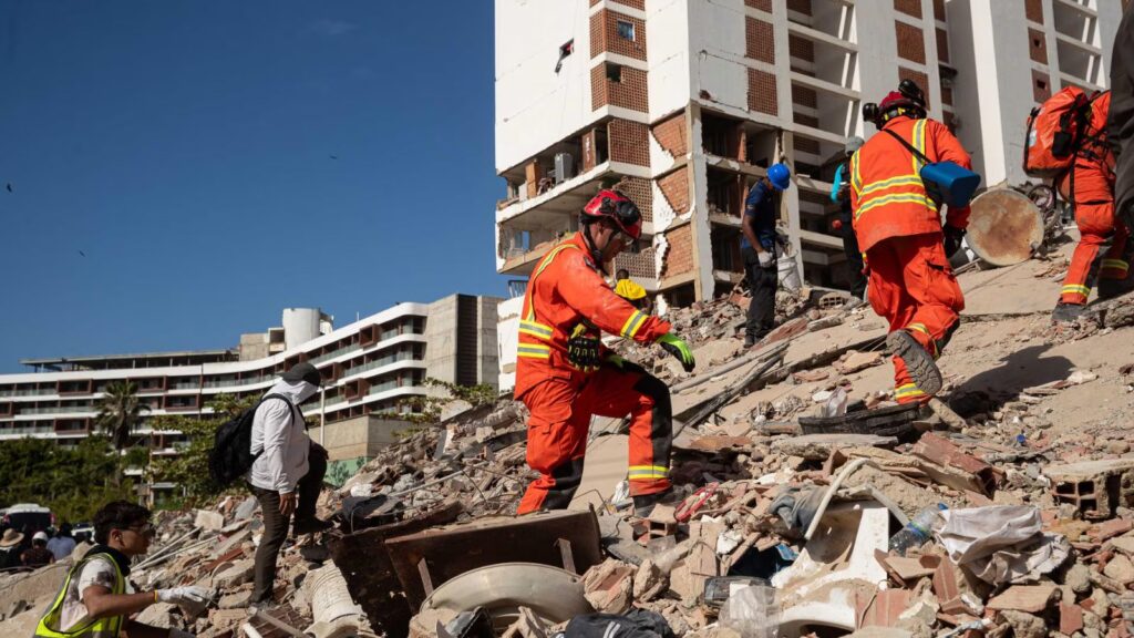 Venezuela faces its worst crisis: Death toll continues to rise Several rescue workers walking across the rubble in search of injured survivors