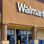 A photo of the exterior of a Walmart store featuring its iconic sign and a brick wall