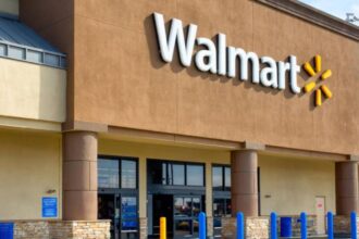 A photo of the exterior of a Walmart store featuring its iconic sign and a brick wall