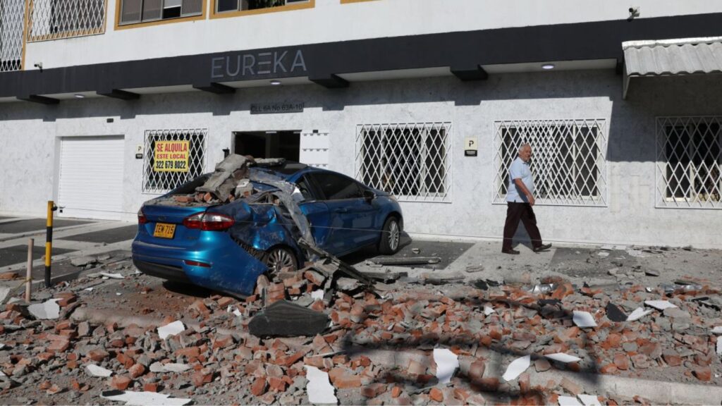 A car and a road covered in debris after several buildings and small houses collapsed in the city of Cali