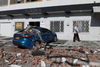 A car and a road covered in debris after several buildings and small houses collapsed in the city of Cali