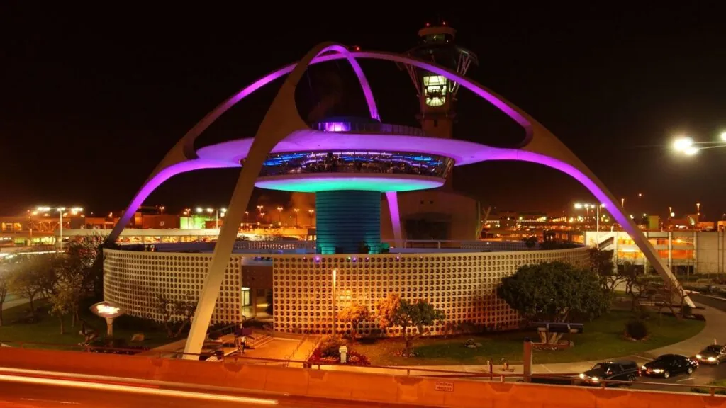 A giant main tower at Los Angeles International Airport with many lights illuminating the outside of the structure