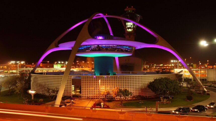 A giant main tower at Los Angeles International Airport with many lights illuminating the outside of the structure