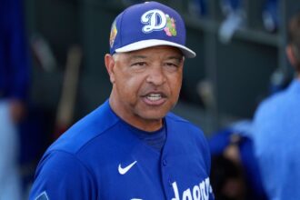 The Dodgers' manager with an angry expression while in the dugout with the rest of his players
