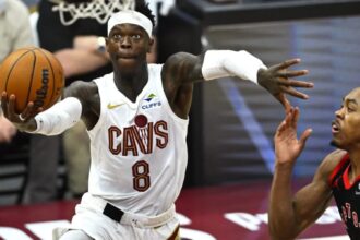The German point guard staying in the air to make a basket while using his other hand to shield his opponent