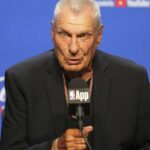 Don Nelson sitting in front of several microphones and speaking to everyone in attendance