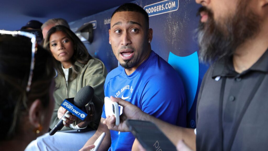 Díaz talking with several reporters on the bench at the Dodgers' training stadium