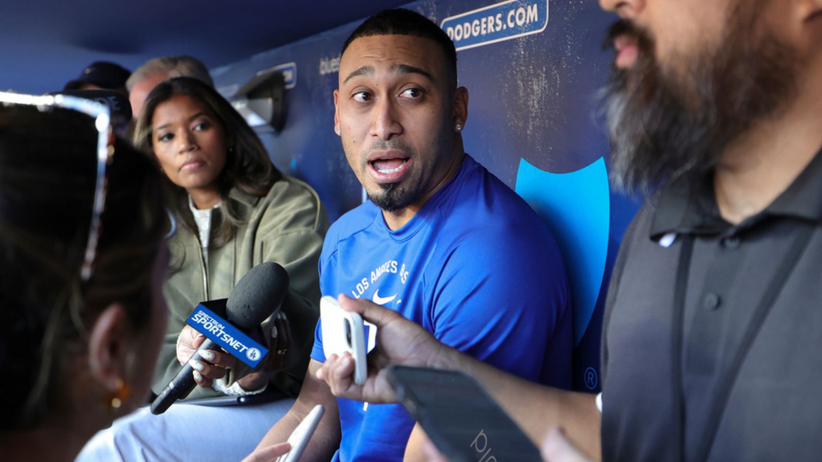 Díaz talking with several reporters on the bench at the Dodgers' training stadium
