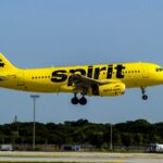 A Spirit Airlines plane taking off after departing from an airport runway