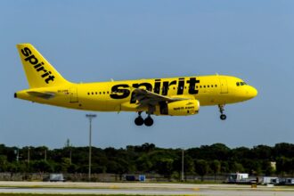 A Spirit Airlines plane taking off after departing from an airport runway