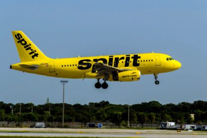 A Spirit Airlines plane taking off after departing from an airport runway