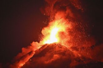 "A volcano in the middle of an eruption, sending massive amounts of lava high into the air