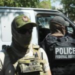 ICE awards $16.7 million contract for 6,000 electric-shock gloves Two uniformed ICE agents wearing vests and face masks to avoid being recognized
