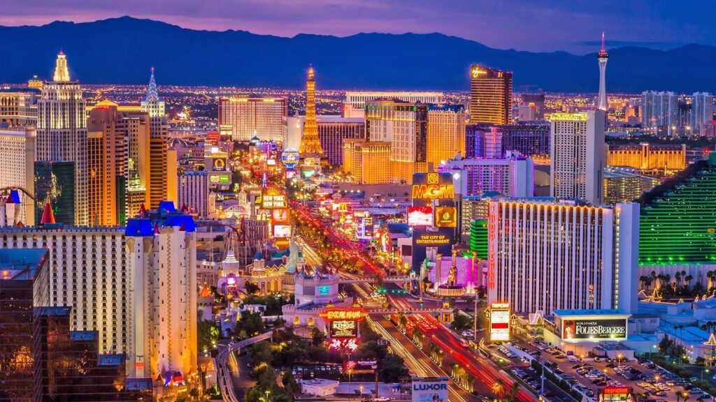 A view of Las Vegas with many cars and people on the streets, while the lights of its beautiful buildings remain illuminated