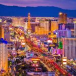 Las Vegas faces another tourism decline as airline emerges as a key factor A view of Las Vegas with many cars and people on the streets, while the lights of its beautiful buildings remain illuminated