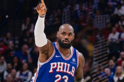 An image of the King wearing a Philadelphia jersey with the number 23, raising his hand after scoring a point