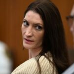 Clancy sitting in court, looking back at her defense attorneys and the audience
