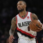 Dame holding the ball as he drives toward the opposing basket.