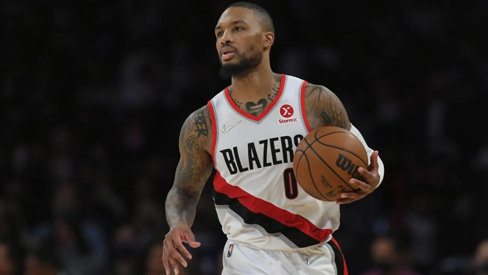 Dame holding the ball as he drives toward the opposing basket.