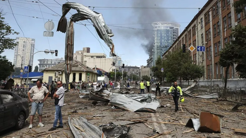 Part of the city of Kyiv with destroyed cars and many people trying to help