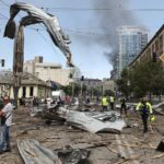 Part of the city of Kyiv with destroyed cars and many people trying to help