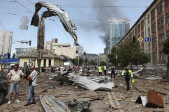 Part of the city of Kyiv with destroyed cars and many people trying to help