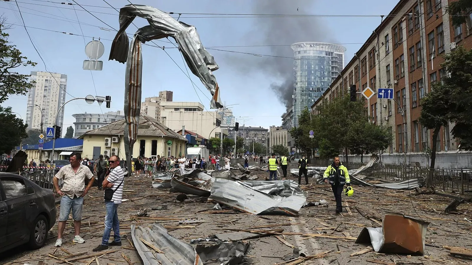 Part of the city of Kyiv with destroyed cars and many people trying to help