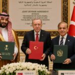 The three leaders of the major nations posing together for a photo while holding the signed agreements