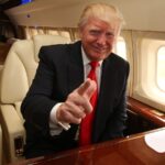 Trump sitting on his presidential plane while smiling