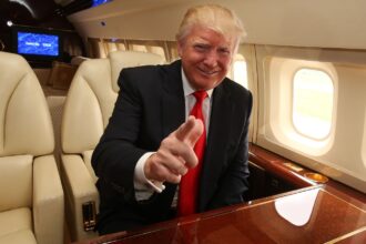 Trump sitting on his presidential plane while smiling