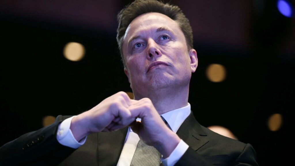 Elon Musk with a very serious expression during a press conference
