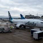An Alaska Airlines plane being loaded with luggage before beginning its journey