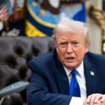 Trump sitting in his office while speaking with several people around him